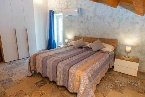 a bedroom with a large bed with blue curtains at B&B Badimà in Fleri