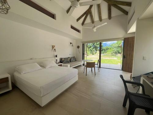 アナポイマにあるRoomy 4BR Villa with Pool at Mesa de Yeguasのベッドルーム(白いベッド1台、テーブル、椅子付)