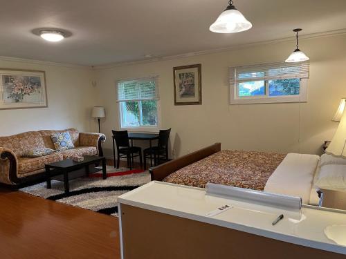 a bedroom with a bed and a couch and a table at Vancouver shaughnessy guest home in Vancouver