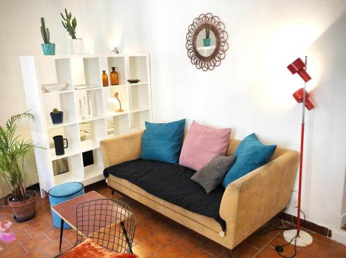 - un salon avec un canapé et des oreillers dans l'établissement Appart de charme CLIM 37m2 T1 Hôtel de ville, à Aix-en-Provence
