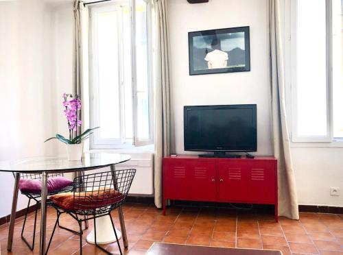 Il comprend un salon doté d'une télévision et d'une table avec des chaises. dans l'établissement Appart de charme CLIM 37m2 T1 Hôtel de ville, à Aix-en-Provence