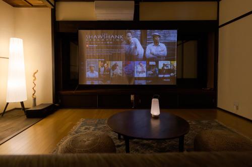 a living room with a tv and a table and a couch at tsumugi tei in Nagiso