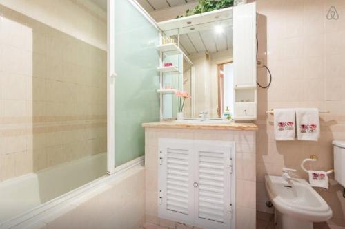 a bathroom with a sink and a tub and a toilet at Brigida's Flat in Faro