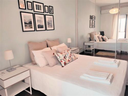 a white bedroom with a large white bed with pillows at Brigida's Flat in Faro