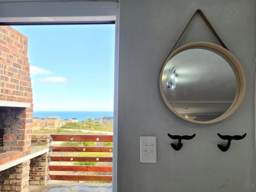 a mirror hanging on a wall next to a door at Silvertree Collective Ocean and Mountain View in Bettyʼs Bay