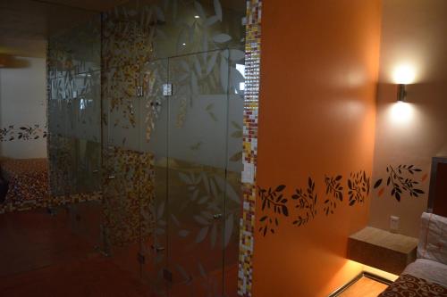 a bathroom with a shower with a glass wall at Hotel Tacuba in Mexico City