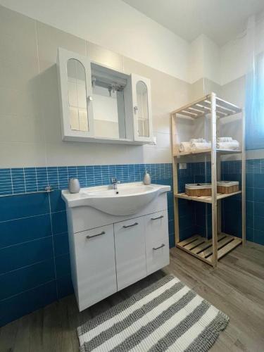 a bathroom with a white sink and blue tiles at Sake' Beach in Senigallia