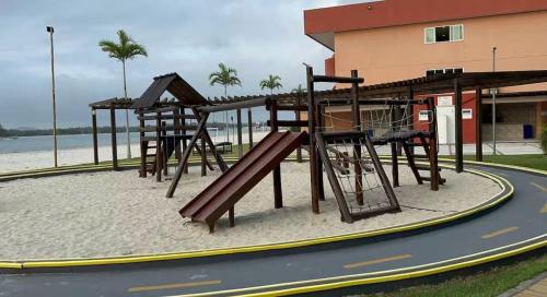 a playground on the beach next to a building at Golden Lake Residence Apart Hotel in Arraial do Cabo