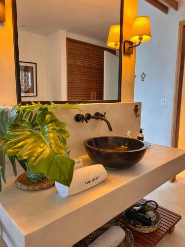 a bathroom with a bowl sink and a mirror at Vila deste Hotel in Búzios