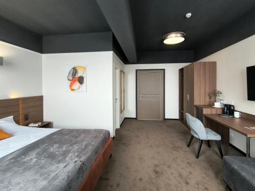 a hotel room with a large bed and a desk at Mini Hotel on Brovarskaya in Kyiv