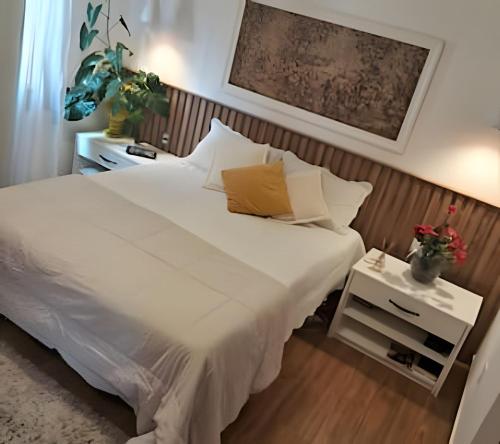 un lit avec des draps blancs et des oreillers dans une chambre dans l'établissement Casa em São Pedro da Aldeia - RJ, à São Pedro da Aldeia