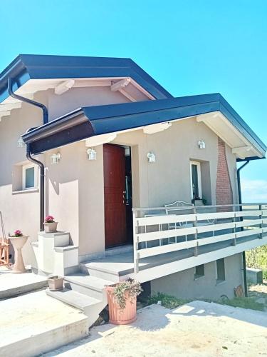 a house with a porch and a red door at NiFe Tiny House - Secret Garden in Montalbo