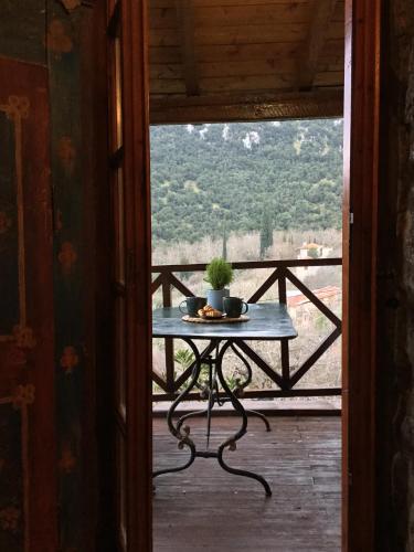 a table with a potted plant on a balcony at MARIOLATA STONE HOUSE in Lílaia