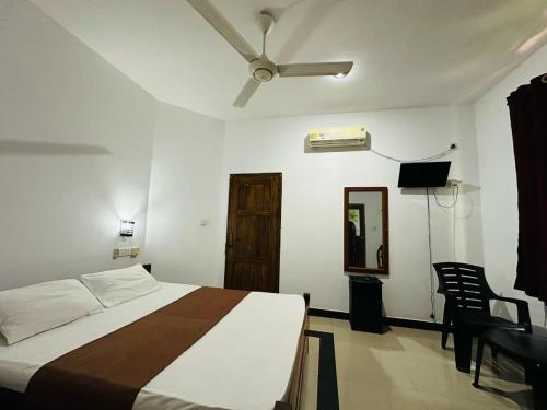 a bedroom with a bed and a ceiling fan at Samudra Luxe Resort in Habarana