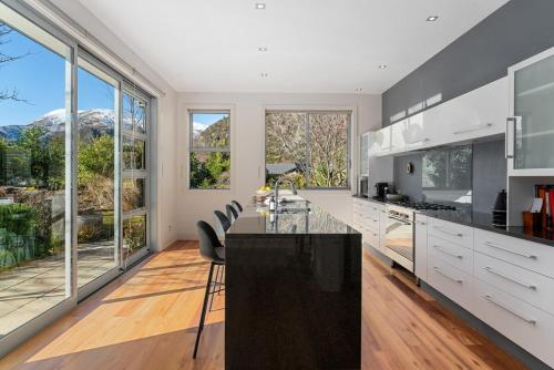 a kitchen with white cabinets and a large window at Kinsale- 3 Bedroom Home in Arrowtown