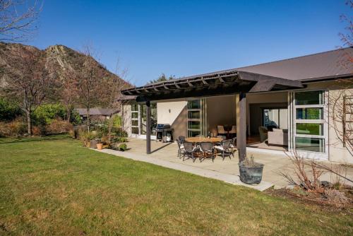 a house with a patio with a table and chairs at Kinsale- 3 Bedroom Home in Arrowtown