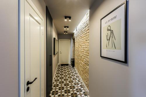 a hallway with a tile floor and a picture on the wall at Velvet Apartment in Rīga