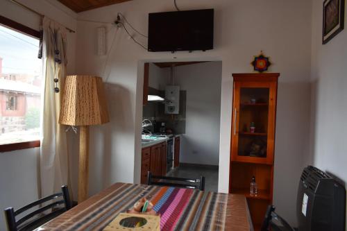 a dining room with a table and a kitchen at Miskysisa in Humahuaca