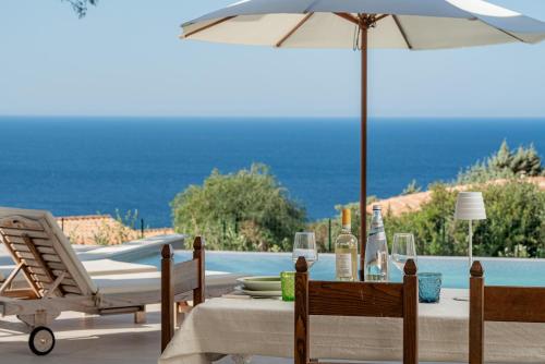 a table with an umbrella next to a pool at Costa Paradiso Resort in Costa Paradiso
