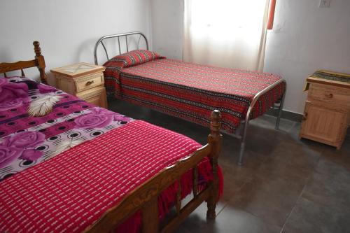 a room with two beds and a dresser in it at Miskysisa in Humahuaca