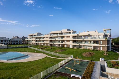 an apartment complex with a playground and a building at Los Colibríes, Beach & Golf - By AC REAL in Isla Canela