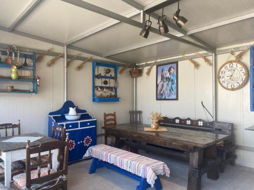 a dining room with a wooden table and a clock at Casa Soarelui in Murighiol