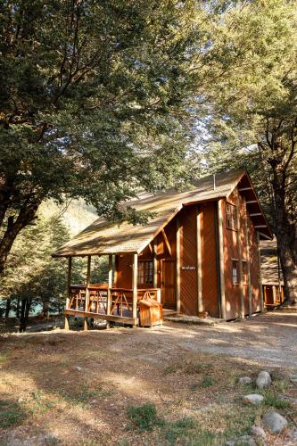 a large wooden cabin in a forest with trees at Green Baker Lodge in Puerto Bertrand