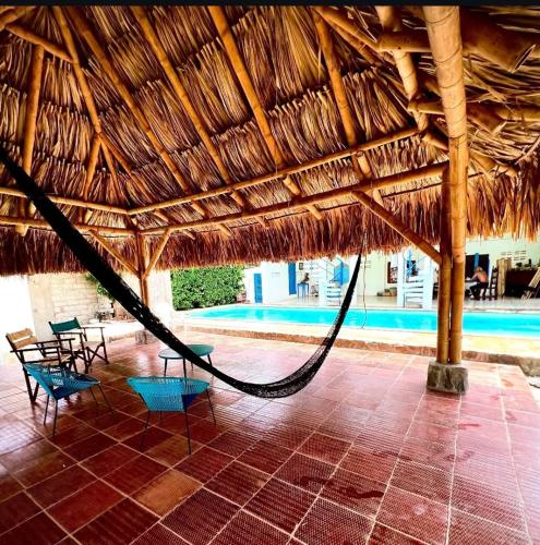 a hammock in a straw hut with a swimming pool at The Bonito Place in Taganga