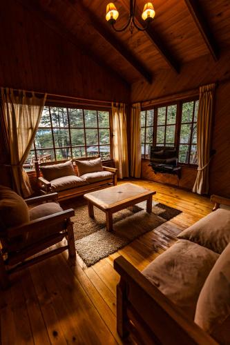 a living room with a couch and a coffee table at Green Baker Lodge in Puerto Bertrand
