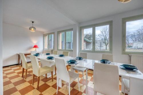 une salle à manger avec une table et des chaises blanches dans l'établissement La Sainte du Drac - 10 Personnes, à Champ-sur-Drac