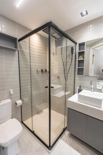 a bathroom with a shower and a toilet and a sink at Arpoar Flat 118 - De frente para o mar in João Pessoa