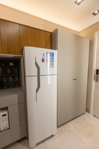 a white refrigerator in a kitchen next to a stove at Arpoar Flat 118 - De frente para o mar in João Pessoa