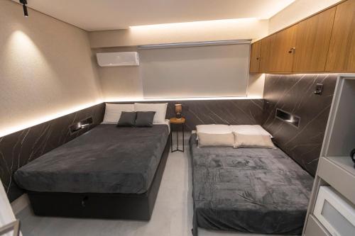 a small bedroom with two beds in a small room at Arpoar Flat 118 - De frente para o mar in João Pessoa