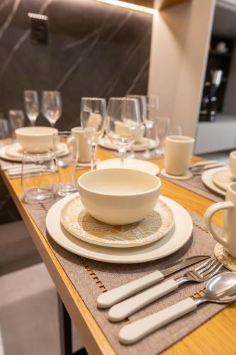 a table with plates and wine glasses on it at Arpoar Flat 118 - De frente para o mar in João Pessoa
