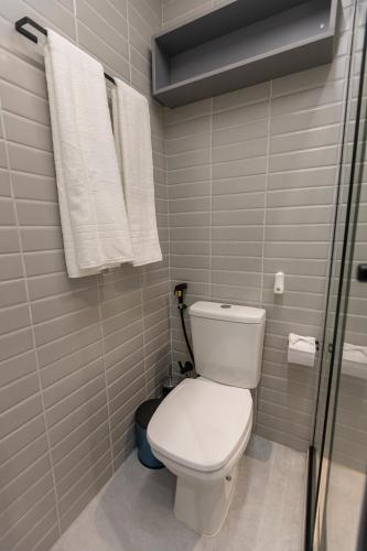a bathroom with a white toilet and a shower at Arpoar Flat 118 - De frente para o mar in João Pessoa