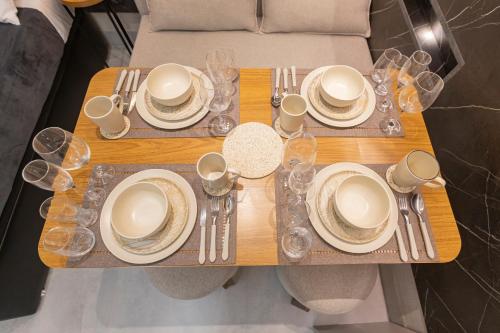 a wooden table with plates and silverware on it at Arpoar Flat 118 - De frente para o mar in João Pessoa