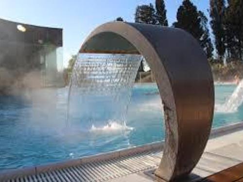 une fontaine en face d'une piscine dans l'établissement Charmant T1 à Balaruc-les-Bains avec balcon, animaux admis - FR-1-503-76, à Balaruc-les-Bains