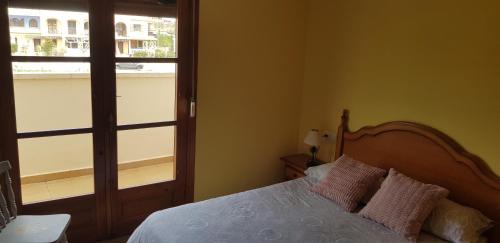 a bedroom with a bed with two pillows and a window at Junto a la playa y vistas al mar in Los Alcázares