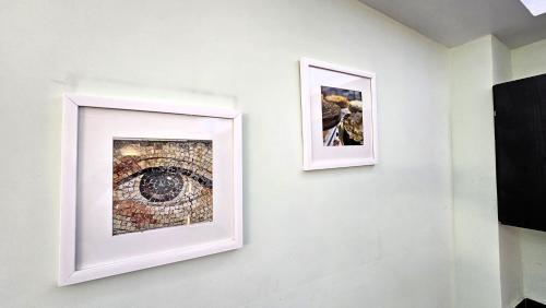 two framed pictures of an eye on a wall at A22 SUITE BLACK MAX para 2 a 4 personas, Especialistas Cortas Medianas Largas Estancias, en IZCALLI TEPOTZOTLAN perfecto para Familias, Turistas, Contratistas, Estudiantes, Empresas A sólo 5 min Izcalli 5 min Esmeralda 20 min Satélite 25 min AIFA in Cuautitlán Izcalli