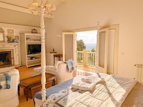 a living room with a bed and a fireplace at Villa Coração Guesthouse by Concavus in Monte Verde