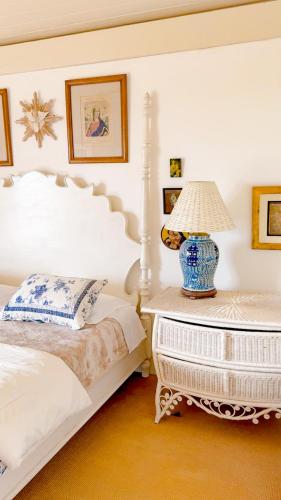 a bedroom with a bed and a table with a lamp at Villa Coração Guesthouse by Concavus in Monte Verde