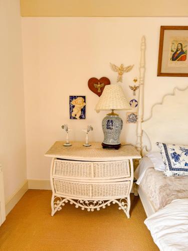 a bedroom with a table with a lamp on it at Villa Coração Guesthouse by Concavus in Monte Verde