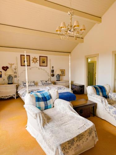 a bedroom with four beds and a chandelier at Villa Coração Guesthouse by Concavus in Monte Verde