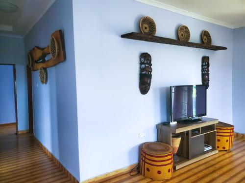 a living room with a tv and a stool at Sweet Retreat in Lusaka