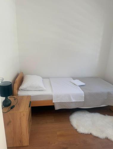 a bed in a room with a nightstand and a bed sidx sidx sidx sidx at Apartmani Franciska in Jajce