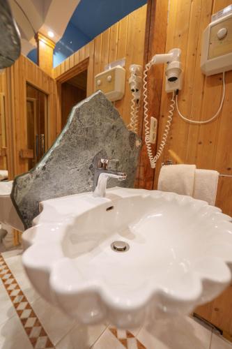 a bathroom with a white sink and a rock at Hotel Plankl in Altötting