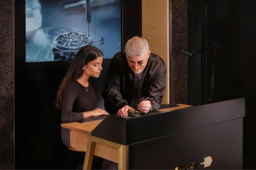 a man and a woman looking at a table at The Ritz-Carlton Hotel de la Paix, Geneva in Geneva