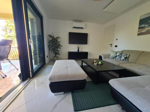 una sala de estar con un sofá y una mesa en Botanica House Krk, en Njivice