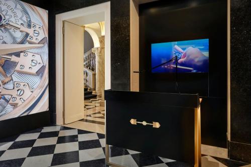 a room with a tv and a checkered floor at The Ritz-Carlton Hotel de la Paix, Geneva in Geneva