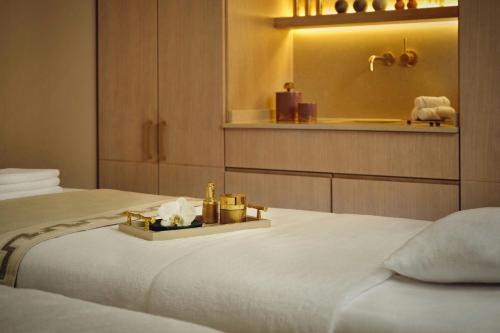 a hotel room with two beds and a mirror at The Ritz-Carlton Hotel de la Paix, Geneva in Geneva